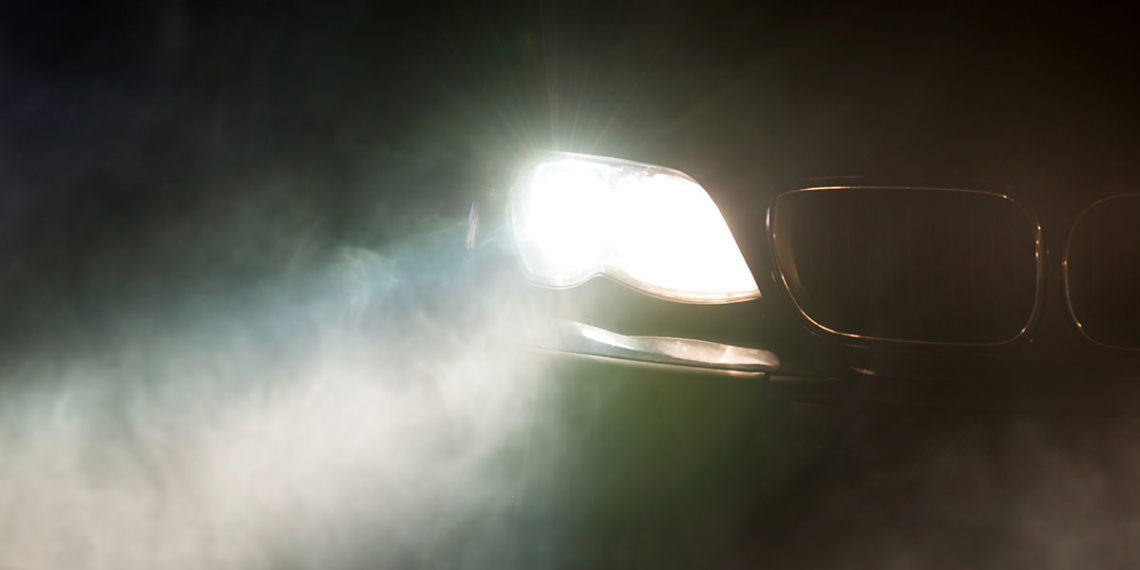 Night Car With Bright Headlights Approaching In The Dark