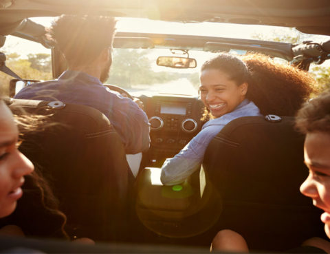 young family driving in car with kids