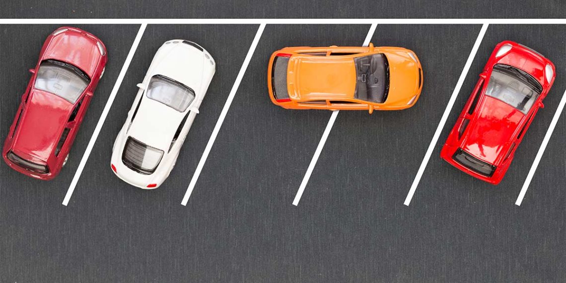 several cars parked properly with one car double parked