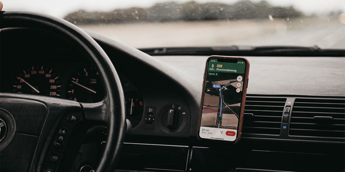 Interior of car with steering wheel and smartphone GPS mounted to the air vent