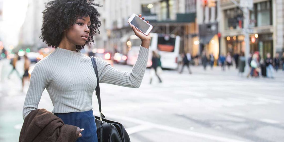 Woman flagging a cab or rideshare car.