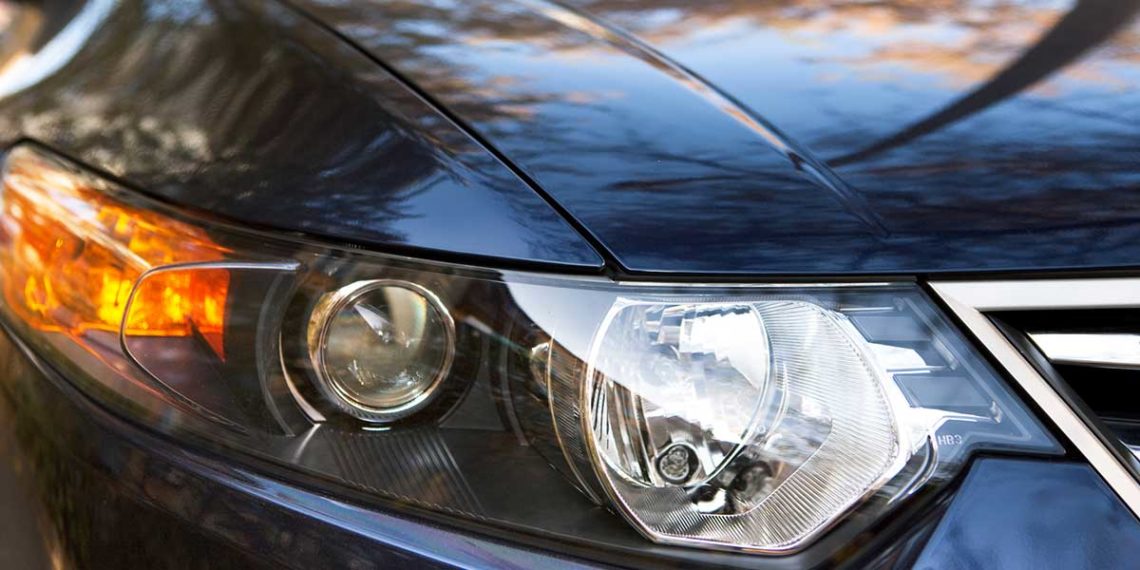 Up-close shot of a black car’s passenger-side headlight.
