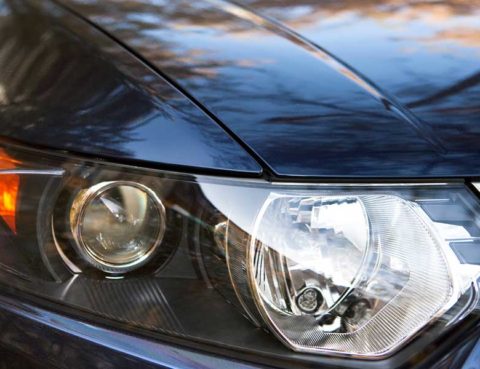 Up-close shot of a black car’s passenger-side headlight.